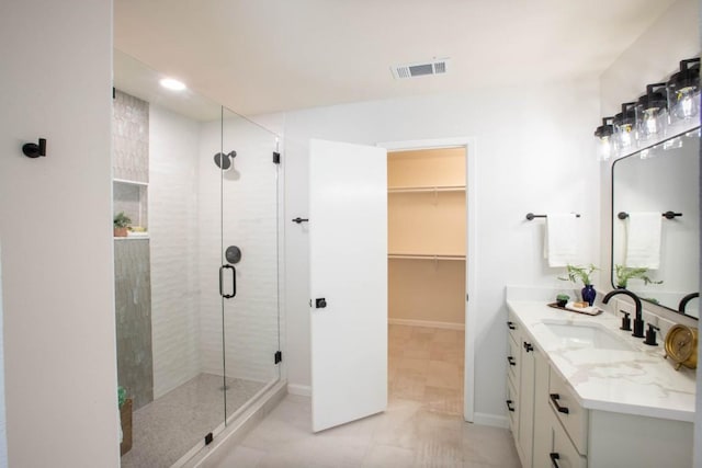 bathroom featuring vanity, a shower with shower door, and tile patterned flooring