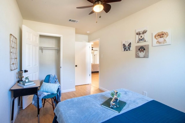 bedroom with light hardwood / wood-style flooring, ceiling fan, and a closet