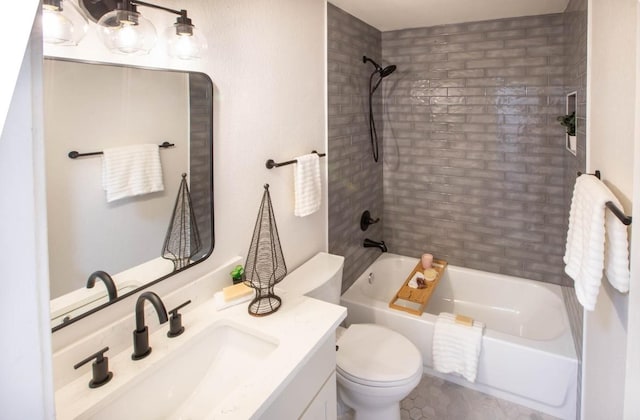 full bathroom with tiled shower / bath, vanity, and toilet