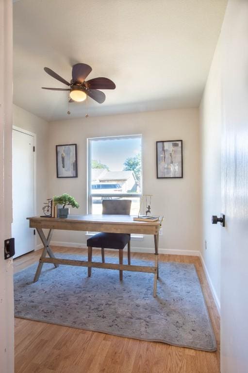 office with light hardwood / wood-style flooring and ceiling fan