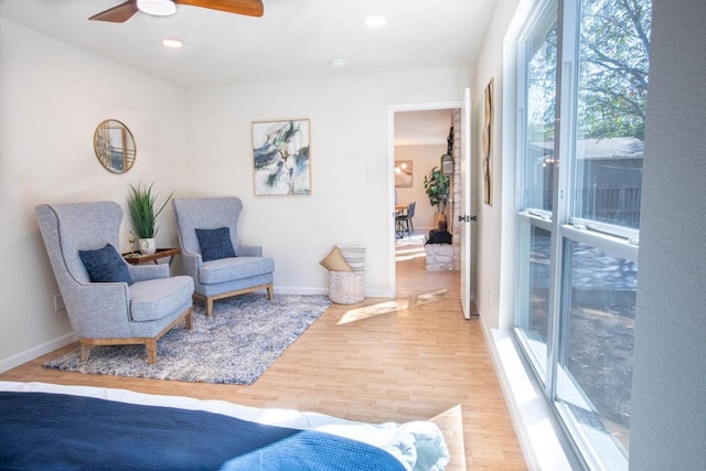 living area with ceiling fan and hardwood / wood-style floors