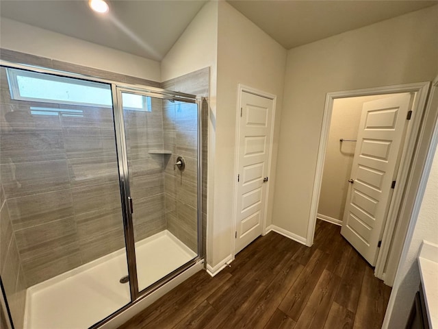 bathroom featuring vanity, vaulted ceiling, wood-type flooring, and walk in shower