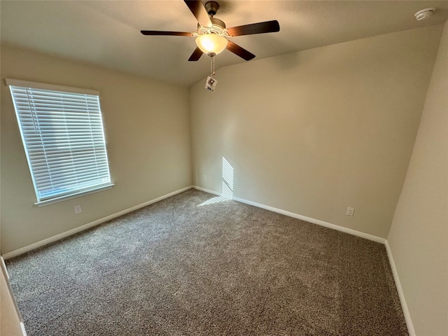 empty room with vaulted ceiling, carpet floors, and ceiling fan