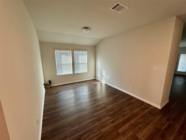 unfurnished room featuring lofted ceiling and dark hardwood / wood-style floors