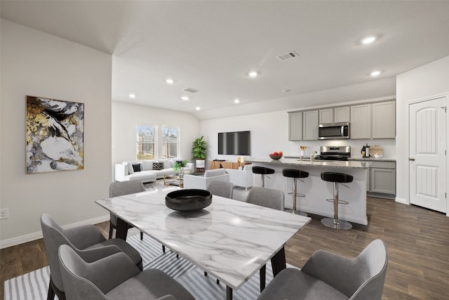 dining area with sink and dark wood-type flooring