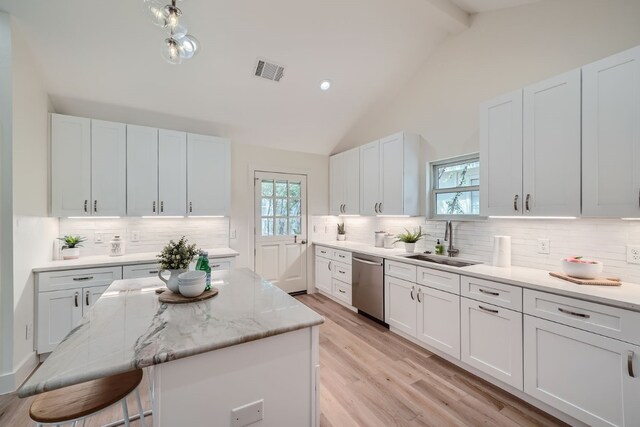 kitchen featuring plenty of natural light, backsplash, a center island, and stainless steel dishwasher