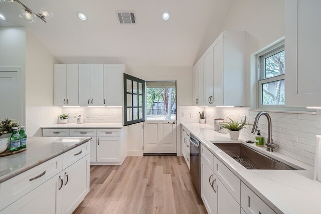 kitchen with white cabinetry, decorative backsplash, sink, and plenty of natural light