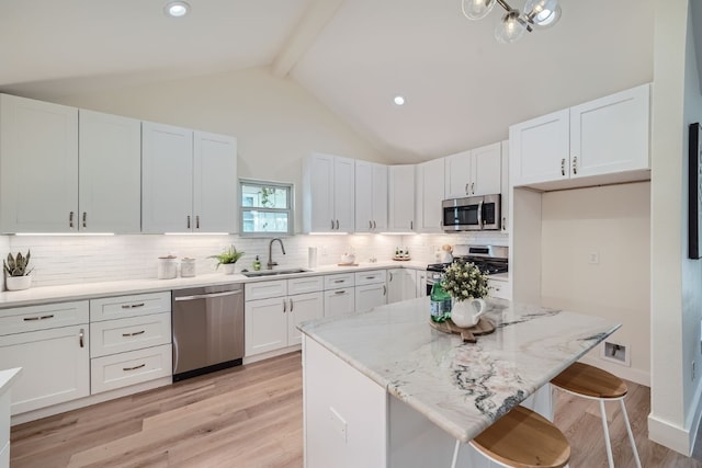 kitchen featuring sink, tasteful backsplash, light hardwood / wood-style flooring, white cabinetry, and stainless steel appliances