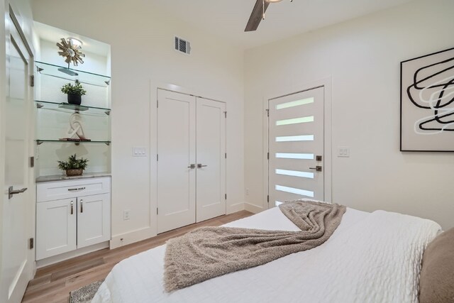 bedroom with a closet, ceiling fan, and light hardwood / wood-style flooring