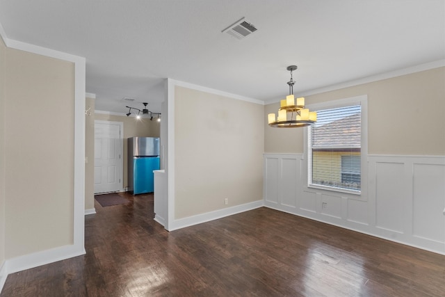 empty room featuring ornamental molding, dark wood-type flooring, and a chandelier