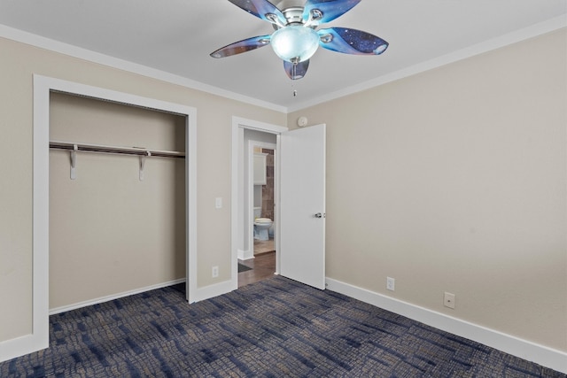 unfurnished bedroom with dark carpet, ornamental molding, a closet, and ceiling fan