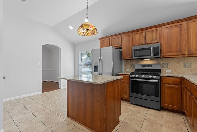 kitchen featuring a kitchen island, stainless steel appliances, backsplash, vaulted ceiling, and light stone counters