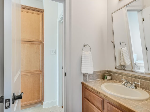 bathroom with tile patterned floors, decorative backsplash, vanity, and toilet