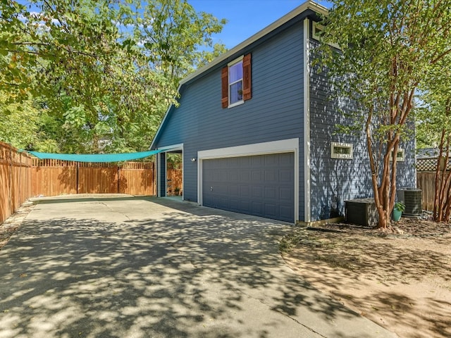 exterior space with central AC and a garage