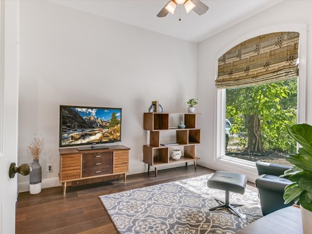 sitting room with ceiling fan and dark wood-type flooring