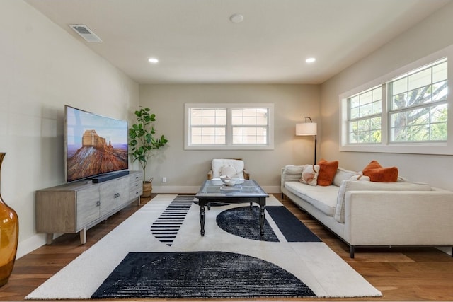 living room featuring plenty of natural light and dark hardwood / wood-style flooring