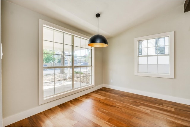 unfurnished dining area featuring hardwood / wood-style flooring and vaulted ceiling