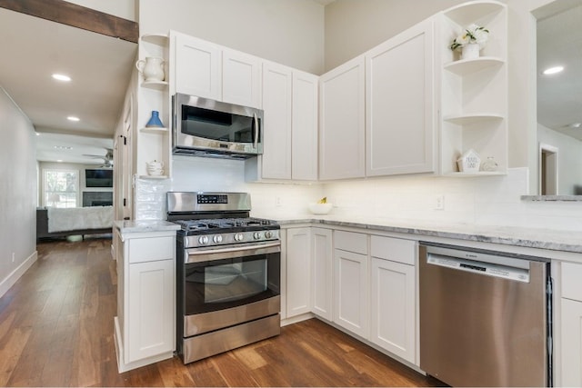 kitchen featuring tasteful backsplash, stainless steel appliances, light stone countertops, dark hardwood / wood-style floors, and white cabinetry