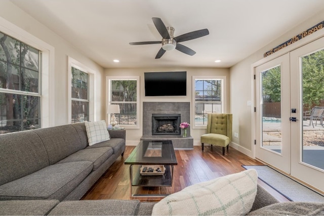 living room with french doors, a tile fireplace, dark hardwood / wood-style flooring, and ceiling fan