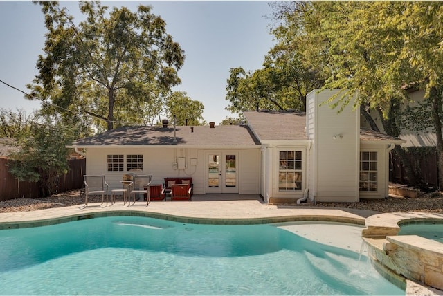 view of swimming pool with an in ground hot tub, a patio, and french doors