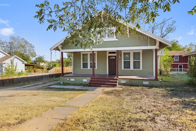 bungalow with a front lawn and covered porch