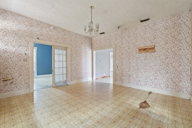 spare room with a chandelier