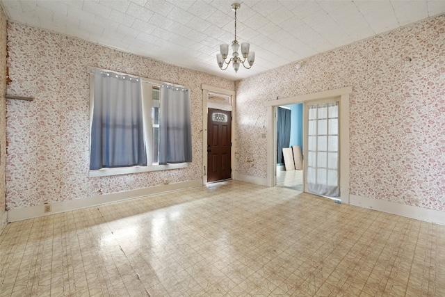 unfurnished room with a chandelier