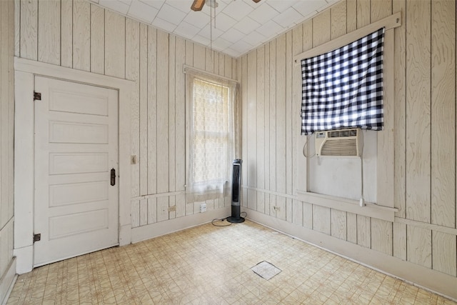 spare room featuring wooden walls and ceiling fan