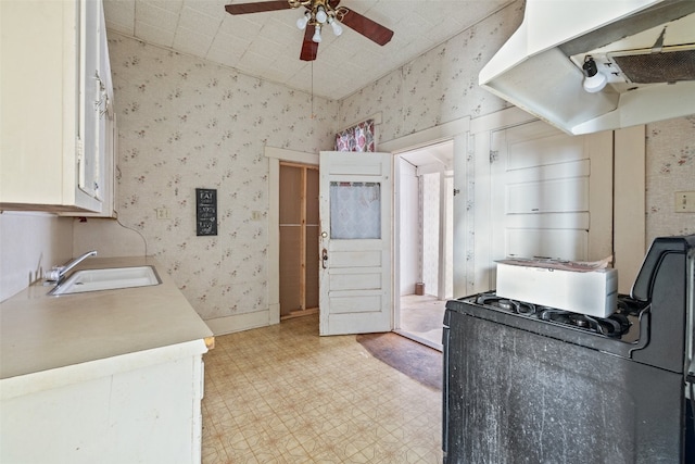 kitchen featuring white cabinetry, ceiling fan, sink, and range hood