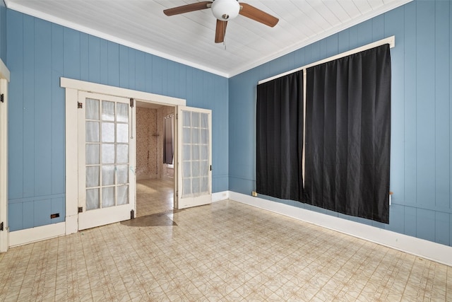 spare room featuring ornamental molding, french doors, wooden walls, and ceiling fan