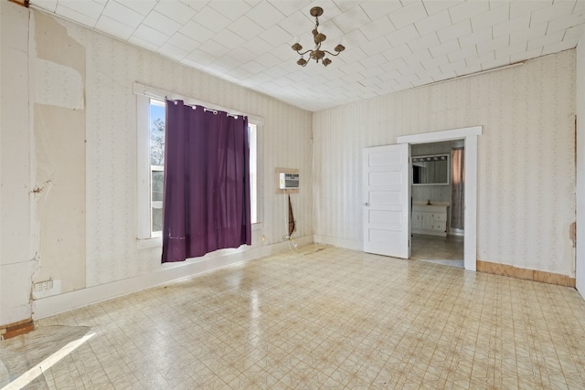 spare room with a chandelier and a wall mounted AC