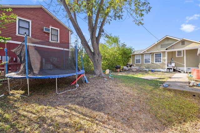 view of yard with a trampoline and a patio