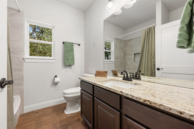 full bathroom with shower / tub combo with curtain, vanity, hardwood / wood-style flooring, and toilet