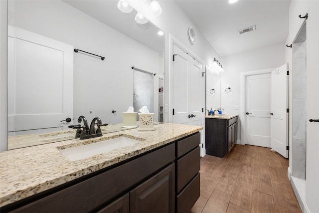 bathroom with vanity, walk in shower, and hardwood / wood-style floors