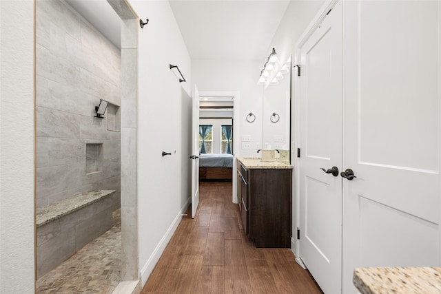 bathroom with vanity, a tile shower, and hardwood / wood-style flooring