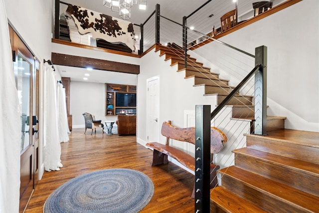 entrance foyer featuring a towering ceiling and hardwood / wood-style floors