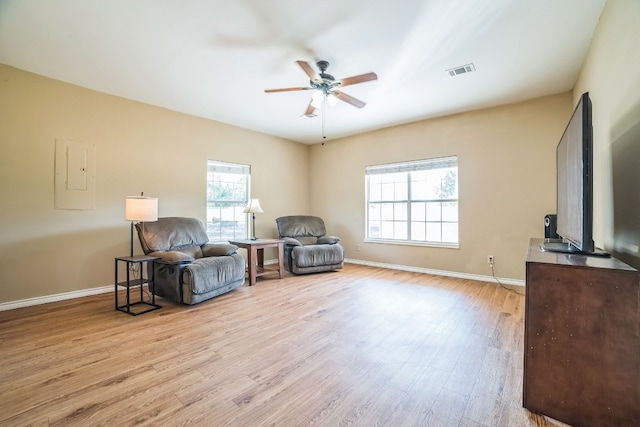 living area featuring ceiling fan, electric panel, and light hardwood / wood-style flooring