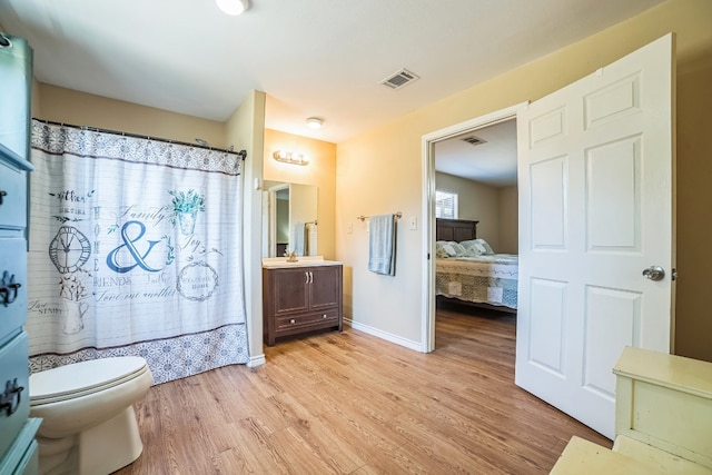 bathroom featuring hardwood / wood-style floors, vanity, toilet, and a shower with shower curtain