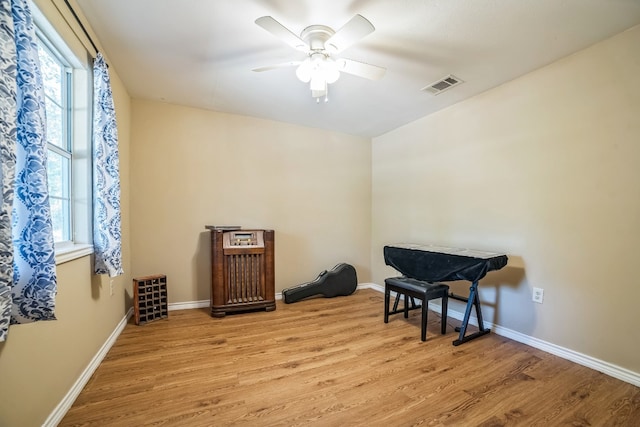 living area with ceiling fan, a healthy amount of sunlight, and light wood-type flooring