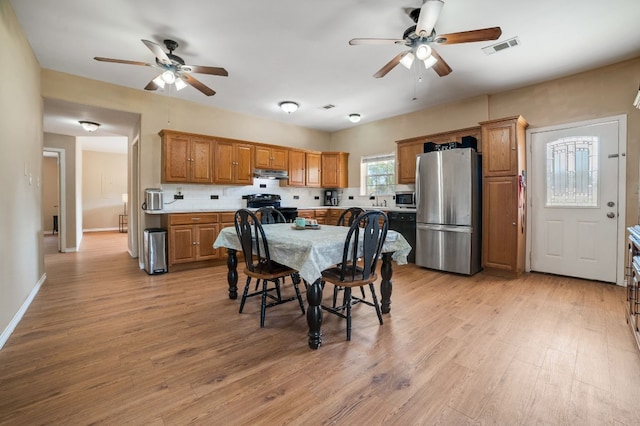 dining room with light hardwood / wood-style floors, ceiling fan, and sink