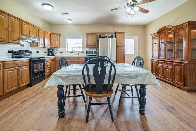 kitchen with stainless steel appliances, tasteful backsplash, light hardwood / wood-style floors, and sink