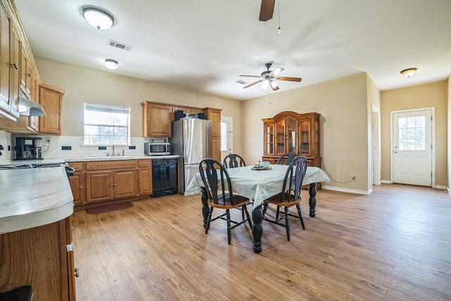 dining space featuring light hardwood / wood-style flooring, ceiling fan, and sink