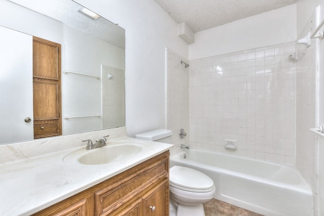 full bathroom with vanity, tile patterned floors, washtub / shower combination, toilet, and a textured ceiling