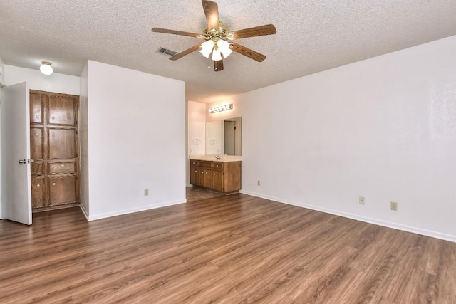 spare room featuring dark hardwood / wood-style flooring, a textured ceiling, and ceiling fan