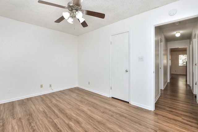 unfurnished bedroom with ceiling fan, wood-type flooring, and a textured ceiling