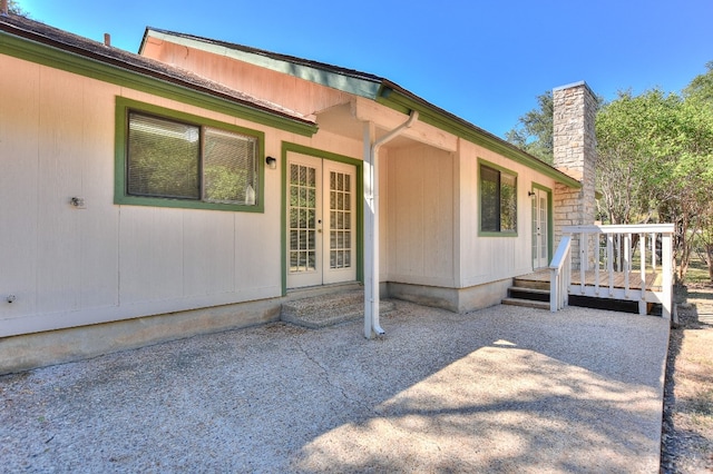 entrance to property with a patio area, french doors, and a deck