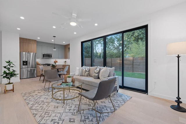 living room with light hardwood / wood-style floors and ceiling fan