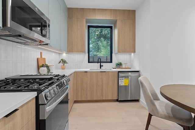 kitchen featuring light brown cabinetry, sink, appliances with stainless steel finishes, and tasteful backsplash