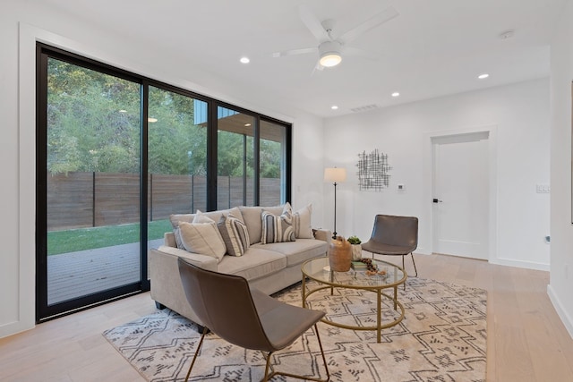 living room with light hardwood / wood-style flooring and ceiling fan