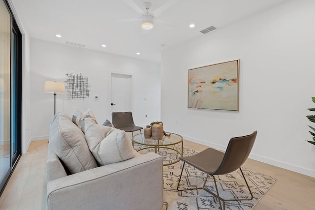 living room featuring light hardwood / wood-style floors and ceiling fan